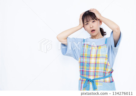 一位家庭主婦抱著頭，臉色蒼白。 134276011