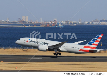 起飛，一架客機正在爬升。美國航空公司的飛機從羽田機場起飛。 134276850