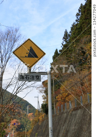 Road sign of falling rock attention 134277049