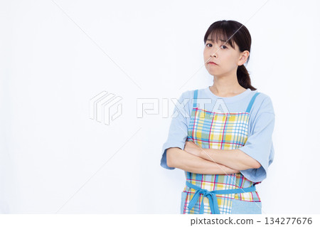 一位心事重重的家庭主婦，雙手交叉抱在胸前。 134277676