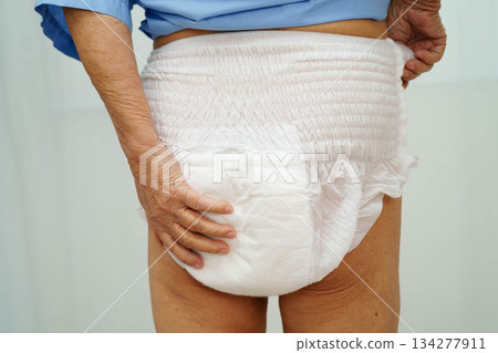 Asian senior woman patient wearing adult incontinence diaper pad in hospital. Asian senior woman patient wearing adult incontinence diaper pad in hospital. 134277911