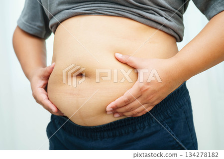 Asian woman use hand to squeeze fat belly big size overweight and obesity. Asian woman use hand to squeeze fat belly big size overweight and obesity. 134278182