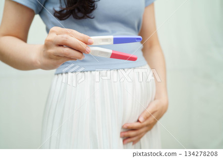Asian holding pregnancy test for female of ovulation day, fetus, maternity, childbirth, birth control. Asian holding pregnancy test for female of ovulation day, fetus, maternity, childbirth, birth control. 134278208