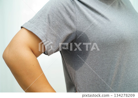 Sweaty underarms, Asian woman with sweat on clothes under armpit. Sweaty underarms, Asian woman with sweat on clothes under armpit. 134278209