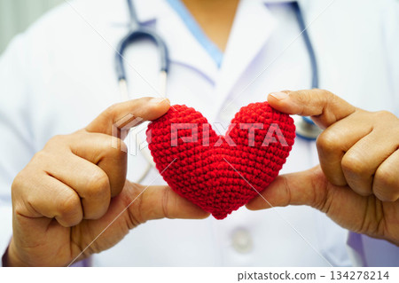 Asian woman doctor holding red heart for health in hospital. Asian woman doctor holding red heart for health in hospital. 134278214