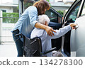 Caregiver help Asian elderly woman disability patient use wheelchair to get in car. 134278300