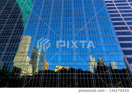 New York City buildings reflect on glass windows in an urban setting New York City buildings reflect on glass windows in an urban setting 134278420