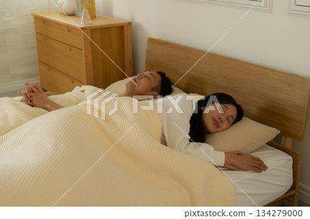 A couple sleeping in bed 134279000