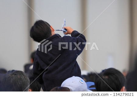 A boy playing with a Blue Impulse model while sitting on his shoulders 134279021