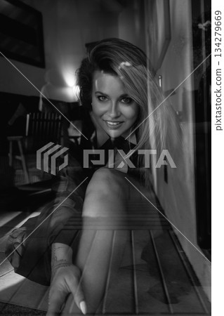 A beautiful Caucasian blonde is walking in nature wearing a black hat. The luxury of the territory of an expensive hotel. 134279669