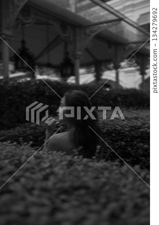 Asian model in bw dress poses gracefully in city park, nature concept 134279692