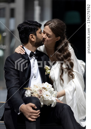 International couple kissing. Indian groom. Street wedding photo shooting. 134279762