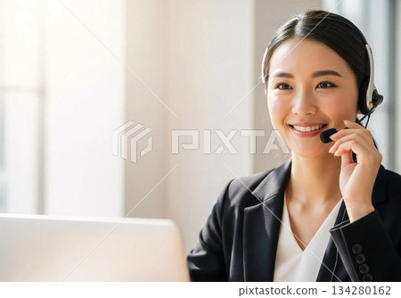 A business scene where a smiling female staff member responds at a call center 134280162