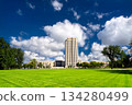 North Dakota State Capitol building stands on green lawn in Bismarck, USA. Art Deco skyscraper features white limestone facade under blue sky 134280499