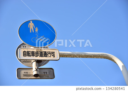 Bicycle and pedestrian walkway signs and blue sky Bicycle and pedestrian walkway signs and blue sky 134280541