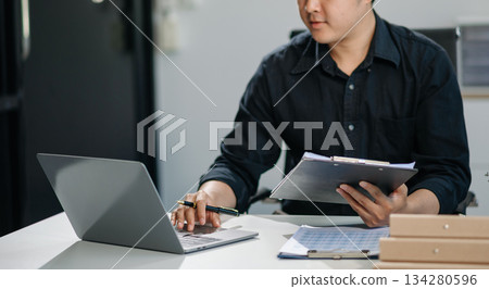 Businessman sitting front tablet ,laptop computer with financial graphs and statistics on monitor Businessman sitting front tablet ,laptop computer with financial graphs and statistics on monitor 134280596