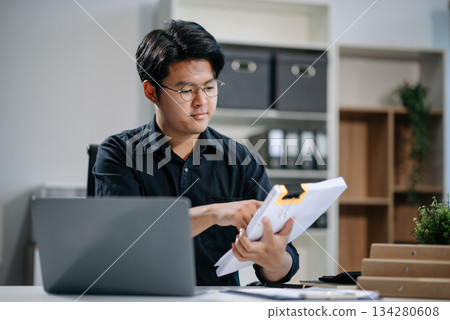 Young businessman working with working notepad, tablet and laptop documents talking on the smartphone, tablet and laptop Young businessman working with working notepad, tablet and laptop documents talking on the smartphone, tablet and laptop 134280608