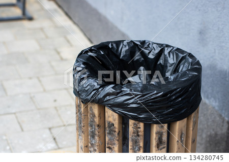 Park maintenance equipment featuring rustic wooden trash container and subtle pavement textures Park maintenance equipment featuring rustic wooden trash container and subtle pavement textures 134280745