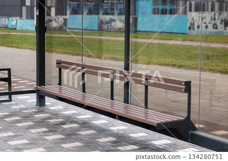 Modern shelter with reflective glass, Bus shelter featuring glass panels and artistic murals Modern shelter with reflective glass, Bus shelter featuring glass panels and artistic murals 134280751