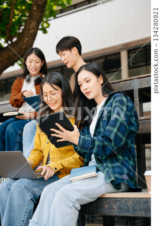 Young Asian People college students and a female student group work at the campus park in morning with her friend 134280921
