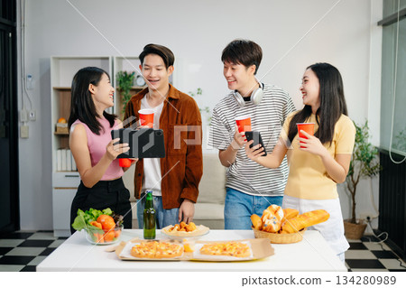 Young Asian friend having, enjoy evening party together at home. Attractive young man and woman having fun, eating food, celebrate at home 134280989