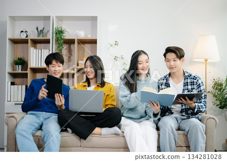 Group of young Asian college students working on his project assignment, using laptop computer and tablet an online informations. together, enjoy talking 134281028