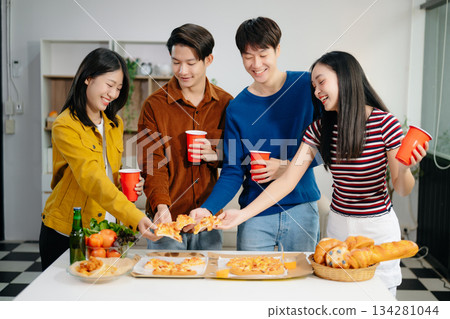 Young Asian friend having, enjoy evening party together at home. Attractive young man and woman having fun, eating food, celebrate at home 134281044