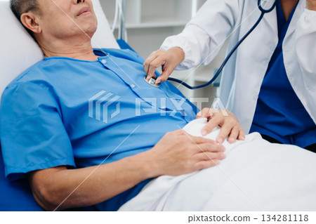 Asian doctor in white suit take notes while discussing and Asian elderly, man patient who lying on bed with receiving saline solution 134281118