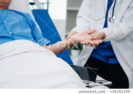 Medical doctor holing senior patient's hands and comforting her Medical doctor holing senior patient's hands and comforting her 134281149
