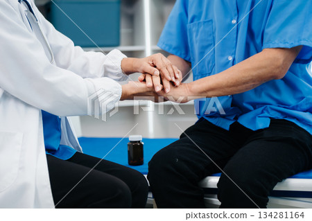 Asian doctor in white suit take notes while discussing and Asian elderly, man patient who lying on bed with receiving saline solution 134281164