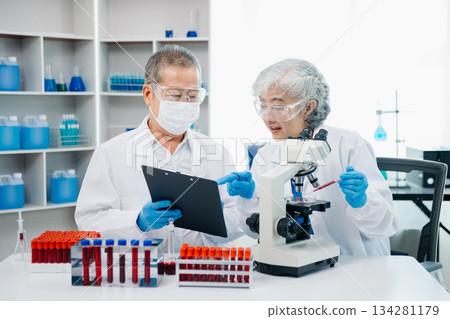 Doctor Talks With Professional Head Nurse or Surgeon, They Use Digital tablet Computer. Diverse Team of Health Care Specialists Discussing Test 134281179