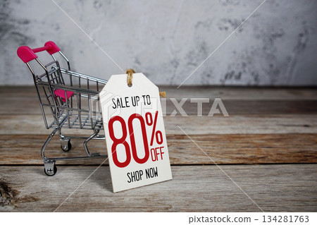 Sale 80% off Shop Now text with trolley shopping cart on wooden background Sale 80% off Shop Now text with trolley shopping cart on wooden background 134281763