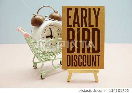 Early Bird Discount text with trolley shopping cart and alarm clock on pink background 134281795