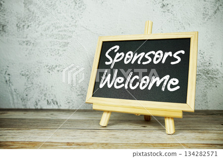 wooden easel displays a blackboard with the bold white text "Sponsors Welcome" set against a rustic wooden surface and textured gray wall background wooden easel displays a blackboard with the bold white text "Sponsors Welcome" set against a rustic wooden surface and textured gray wall background 134282571