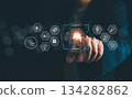 Businessman pointing at glowing AI agents icon with futuristic digital interface, representing artificial intelligence, automation, data analysis, machine learning, and innovative business solutions 134282862