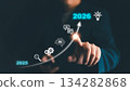Businessman pointing at AI growth trend from 2025 to 2026, symbolizing artificial intelligence innovation, technology progress, digital transformation, future business strategy, and data-driven 134282868