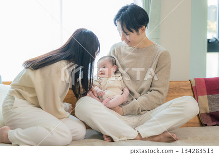 A couple holding a baby 134283513