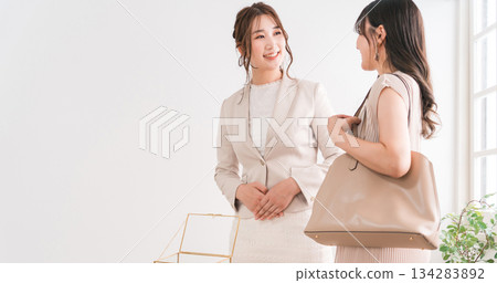 A woman choosing a wedding ring and a salesperson/staff at a jewelry store, accessory store, jewelry shop, or department store 134283892