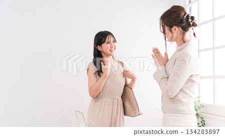 A woman and a salesperson/staff member choosing a ring at a jewelry store, accessory shop, or department store 134283897