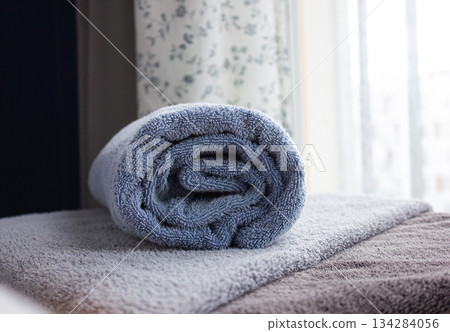 Closeup of blue rolled Bath towel. Towel a on table with copy space. Closeup of blue rolled Bath towel. Towel a on table with copy space. 134284056