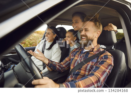 Happy family riding in modern car traveling by automobile together enjoying road trip. Happy family riding in modern car traveling by automobile together enjoying road trip. 134284168