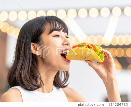 Young woman eating tacos 134284783