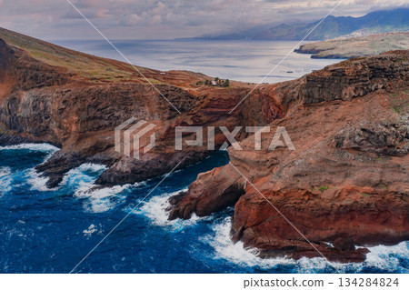 Aerial view of Ponta de Sao Lourenco, Madeira, Portugal, as waves strike ochre and rust rock shelves, stratified lava and jagged headlands in diffused overcast light. Aerial view of Ponta de Sao Lourenco, Madeira, Portugal, as waves strike ochre and rust rock shelves, stratified lava and jagged headlands in diffused overcast light. 134284824