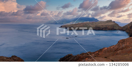 Reddish brown cliffs frame a calm Atlantic bay at Ponta de Sao Lourenco, Madeira, Portugal. Layered headlands and islets appear in soft evening light with long shadows. Reddish brown cliffs frame a calm Atlantic bay at Ponta de Sao Lourenco, Madeira, Portugal. Layered headlands and islets appear in soft evening light with long shadows. 134285006