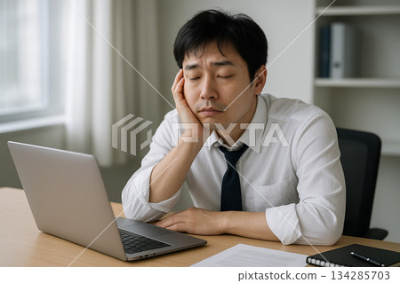 一個看起來因伏案工作而疲憊困倦的男人 134285703