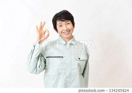 Asian woman in work clothes making an OK sign 134285824