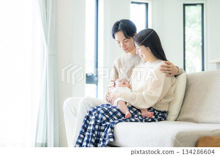 一對夫婦和嬰兒坐在沙發上 134286604