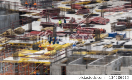 A blurred image of construction workers in safety helmets, building a teamwork on a construction site using scaffolding equipment for urban development and architectural progress. A blurred image of construction workers in safety helmets, building a teamwork on a construction site using scaffolding equipment for urban development and architectural progress. 134286913
