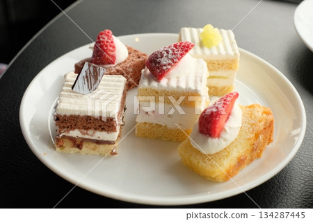 Mini cakes chosen at the buffet and placed on a plate Mini cakes chosen at the buffet and placed on a plate 134287445