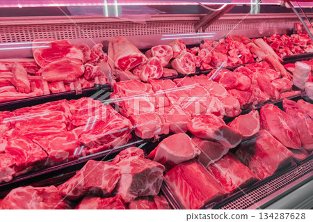 Chilled fresh meat, beef or pork fillet on a display case with red lighting. Meat merchandising at a local supplier's butcher shop. High quality photo 134287628